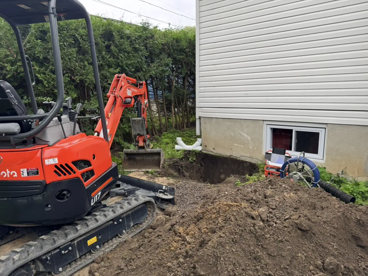 A drain cleaning that led to a line repair: mini excavator along a Gatineau house
